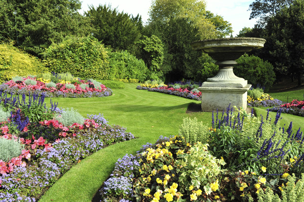 Formal garden landscaping around a central birdbath.